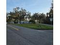 View of light blue home with mature trees and manicured lawn from the street corner at 1026 Lake Jessamine Dr, Orlando, FL 32839
