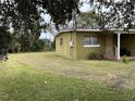 Green side yard with mature trees and landscaping at 110 Country Club Cir, Sanford, FL 32771