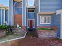 Brick entryway with a red door and arched window at 2395 Windward Cv, Kissimmee, FL 34746