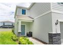 Side entrance with blue door, stone accents, and a small bench at 2472 Dubai St, Kissimmee, FL 34747