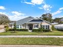 Tan house with gray roof, landscaping, and black shutters at 2583 Grassmoor Loop, Apopka, FL 32712