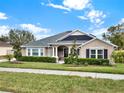 Tan house with gray roof, landscaping, and black shutters at 2583 Grassmoor Loop, Apopka, FL 32712