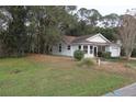 A lovely single-story home is on a lush green lawn surrounded by mature trees at 32512 Oak Park Dr, Leesburg, FL 34748