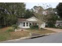 Quaint single-story home with an attached garage, lush front lawn, mature landscaping at 32512 Oak Park Dr, Leesburg, FL 34748