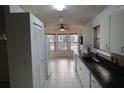 Spacious kitchen with white cabinets, tile flooring, and a window-filled breakfast nook at 32512 Oak Park Dr, Leesburg, FL 34748