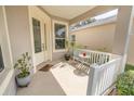 Cozy front porch seating area with a small table, chairs, and a white picket fence at 4969 Rainbow Trout Rd, Tavares, FL 32778