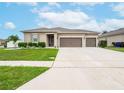 Tan house with double garage and manicured lawn at 5681 Western Sun Dr, St Cloud, FL 34771