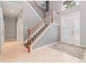 Two-story foyer with tile floors and wooden staircase at 5791 Covington Cove Way, Orlando, FL 32829