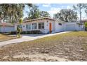Attractive home featuring orange accents, a long driveway, and an attached one-car garage at 814 S Lakeshore Blvd, Lake Wales, FL 33853