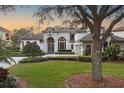 Beautiful home with a large tree in front and a spacious lawn at 8148 Tibet Butler Dr, Windermere, FL 34786