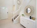 Bright entryway with white staircase, a stylish console table, and a mirror at 8896 Bengal Ct, Kissimmee, FL 34747