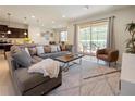 Spacious living room with gray sectional sofa, large TV, and access to a patio at 8896 Bengal Ct, Kissimmee, FL 34747