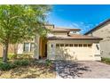 Two-story house with a three-car garage and a brick driveway at 9024 Shadow Mountain St, Davenport, FL 33896