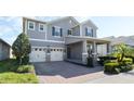 Two-story home with gray siding, two-car garage, and landscaped yard at 9459 Jaywood Rd, Winter Garden, FL 34787