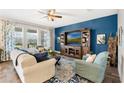 Living room with blue accent wall, large TV, and comfortable seating at 9459 Jaywood Rd, Winter Garden, FL 34787