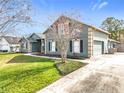 A lovely view of the home's exterior and well-kept yard space are captured on a bright, sunny day at 10010 Crenshaw Cir, Clermont, FL 34711