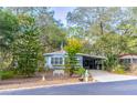 Blue manufactured home on a tree-lined street with a white bench at 151 E Plantation Blvd, Lake Mary, FL 32746