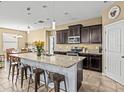 Spacious kitchen featuring granite countertops and a central island with barstool seating at 1882 Rustic Falls Dr, Kissimmee, FL 34744