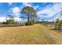 Open grassy paddock with wooden fencing and small barn in background at 2140 W State Road 46, Geneva, FL 32732