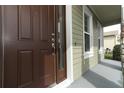 Detailed view of a dark brown front door with sidelight window and craftsman style trim at 341 Skyview Pl, Chuluota, FL 32766