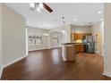 Open-concept living space with wood floors, seamlessly connecting the kitchen and dining areas at 3608 Mount Hope Loop, Leesburg, FL 34748