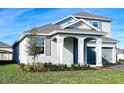 Charming two-story home featuring a well-manicured lawn, gray paint, and a two-car garage at 4425 Lions Gate Ave, Clermont, FL 34711