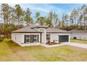 Charming new construction home with manicured lawn, dark gray roof and an attached two car garage at 6732 Sw 132Nd St, Ocala, FL 34473