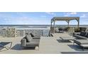 A beautifully furnished deck perfect for outdoor relaxation, featuring comfortable seating and stunning ocean views at 6877 S Atlantic Ave, New Smyrna Beach, FL 32169