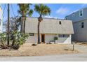 A charming single-Gathering home with a tidy exterior, complemented by sandy landscaping and a neat driveway at 6877 S Atlantic Ave, New Smyrna Beach, FL 32169
