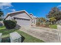 Well-manicured lawn and landscaping surround this home with two-car garage at 9716 Pecky Cypress Way, Orlando, FL 32836