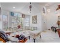 Bright living room featuring high ceilings, large windows, and neutral tile flooring at 9716 Pecky Cypress Way, Orlando, FL 32836