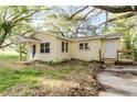 Charming yellow home featuring a covered porch, surrounded by mature trees and natural landscaping at 1032 W 2Nd St, Sanford, FL 32771