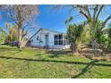 Cozy single-story home featuring a screened-in porch, fenced yard, and mature trees at 105 N Ortman Dr, Orlando, FL 32805