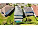 Aerial view of the home showcasing the pool, screened-in patio, and well-maintained green lawn at 10680 Royal Cypress Way, Orlando, FL 32836