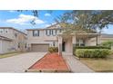 Two-story house with a brown garage door and landscaped yard at 11412 Chateaubriand Ave, Orlando, FL 32836