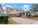 Two-story house with a brown garage door and landscaped yard at 11412 Chateaubriand Ave, Orlando, FL 32836