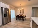 Well-lit dining room features a modern light fixture and a stainless steel refrigerator at 150 Marion Oakes Trl, Ocala, FL 34473