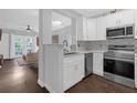 Modern kitchen with white cabinets, stainless steel appliances, and quartz countertops at 202 E South St # 1048, Orlando, FL 32801