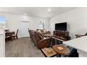 Living area featuring a brown leather sectional sofa and a flat-screen TV at 2559 Relaxing Ln, Kissimmee, FL 34747