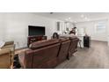 Living room with brown leather reclining sofas and a large TV at 2559 Relaxing Ln, Kissimmee, FL 34747