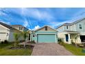 Single-story home with blue garage door, a paved driveway, and well-kept landscaping at 2713 Runners Cir, Clermont, FL 34714