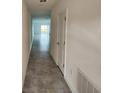 Bright hallway with neutral tile flooring leading to an open living space with a sliding glass door at 2713 Runners Cir, Clermont, FL 34714