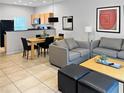 Open living and dining area with gray couches and wooden dining table at 3002 Red Ginger Rd, Kissimmee, FL 34747