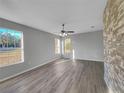 Spacious living room with large windows, neutral walls, and wood-look floors at 3124 Oak Brook Ln, Eustis, FL 32736