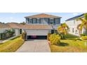 Two-story house with gray siding, open garage, and driveway at 361 Preserve Pointe Blvd, Davenport, FL 33837