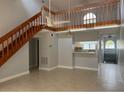 Open concept living room with natural light, wooden staircase, and tiled floor at 4826 Marks Terrace # 389, Orlando, FL 32811