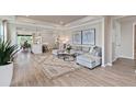 Spacious living room with large windows, hardwood floors, and comfortable seating at 7345 Ivy Tendril Ave, Orlando, FL 32829