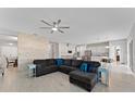 Spacious living room with a ceiling fan opens up to the modern, updated kitchen at 9573 Meadow Hunt Way, Winter Garden, FL 34787