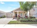 Inviting one-story home featuring a two-car garage and landscaped front yard, with a cozy front porch at 10198 Lovegrass Ln, Orlando, FL 32832