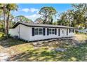Updated ranch home features a white exterior, black shutters, and a nicely landscaped yard at 1021 Flagler Ave, Edgewater, FL 32132
